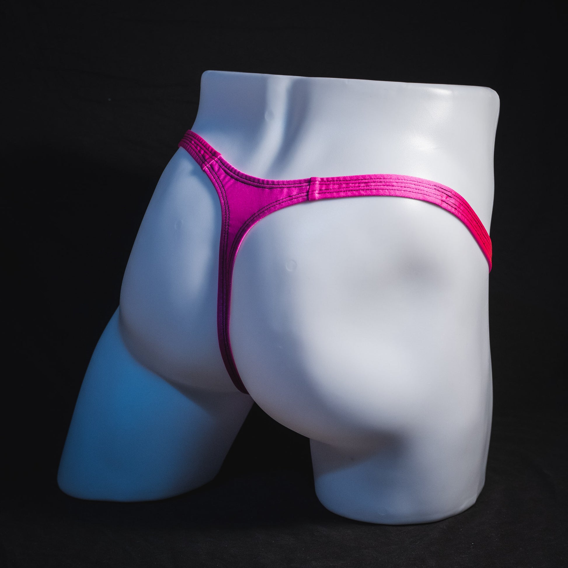 Men's solid pink thong underwear, classic cut, full angled rear view.