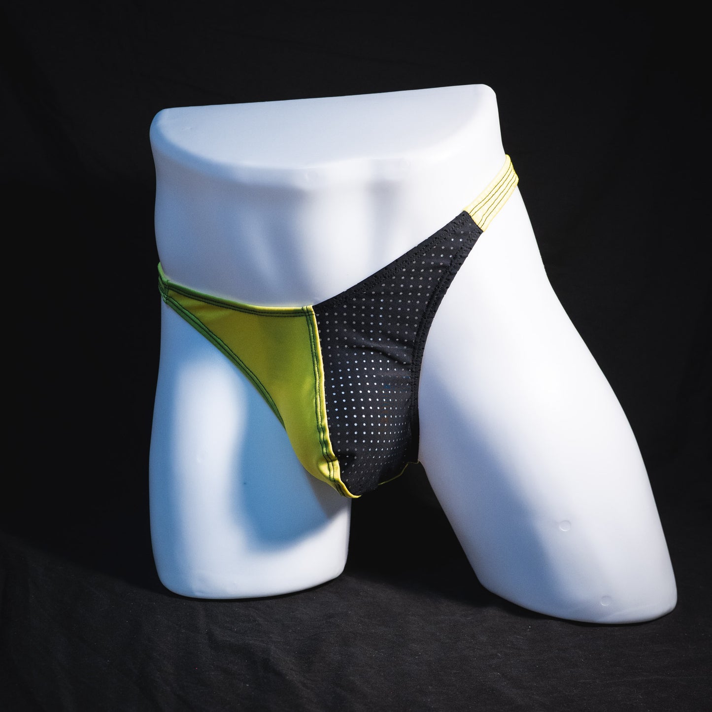 Men's yellow and black mesh thong underwear, classic cut, full angled front view.