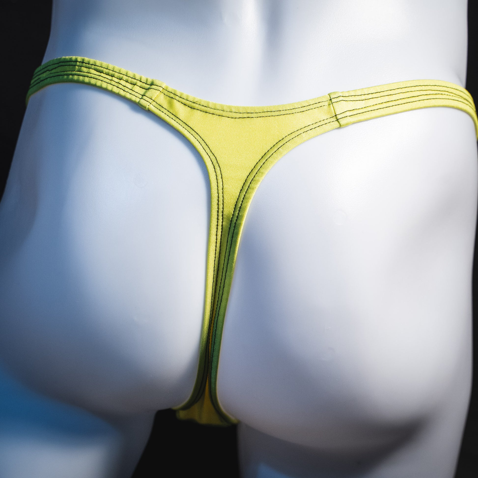 Men's yellow and black mesh thong underwear, classic cut, rear view.