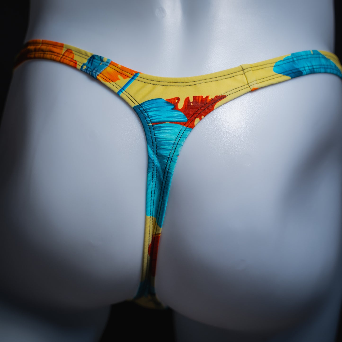 Men's yellow floral thong, slim cut, rear view.