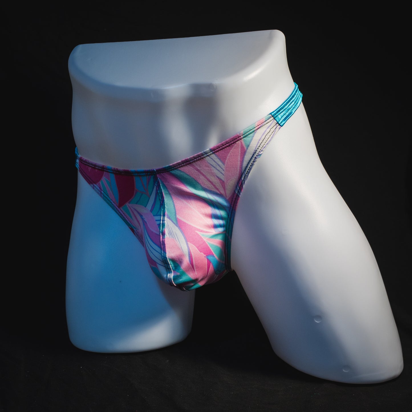 Men's pink and blue feathers thong underwear, classic cut, angled full front view.