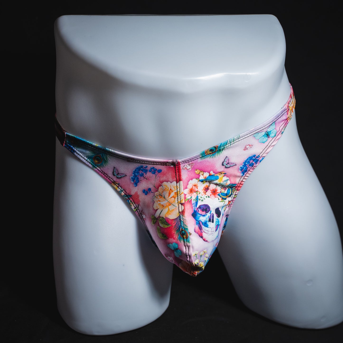 Men's pink skulls and floral thong underwear, classic cut, full front view.