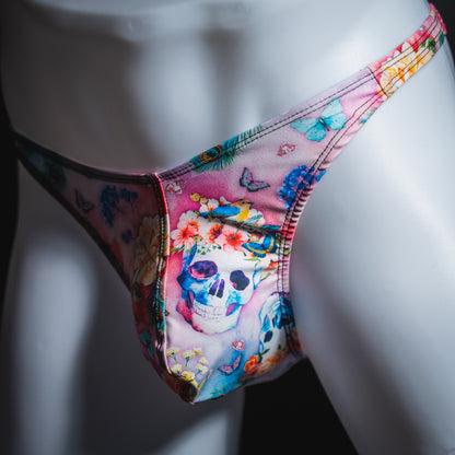 Men's pink skulls and floral thong underwear, classic cut, angled front view.