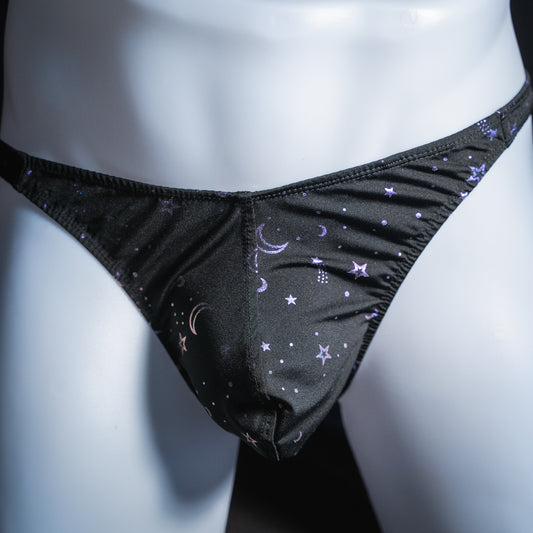 Men's black with purple foil moons and stars thong, classic cut, front view.