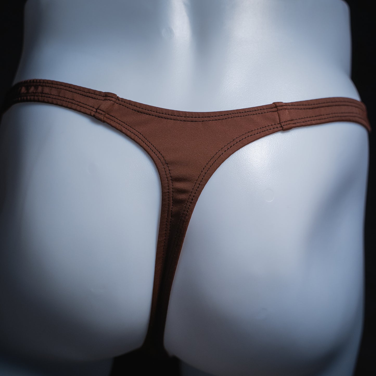 Men's solid brown thong, slim cut, rear view.