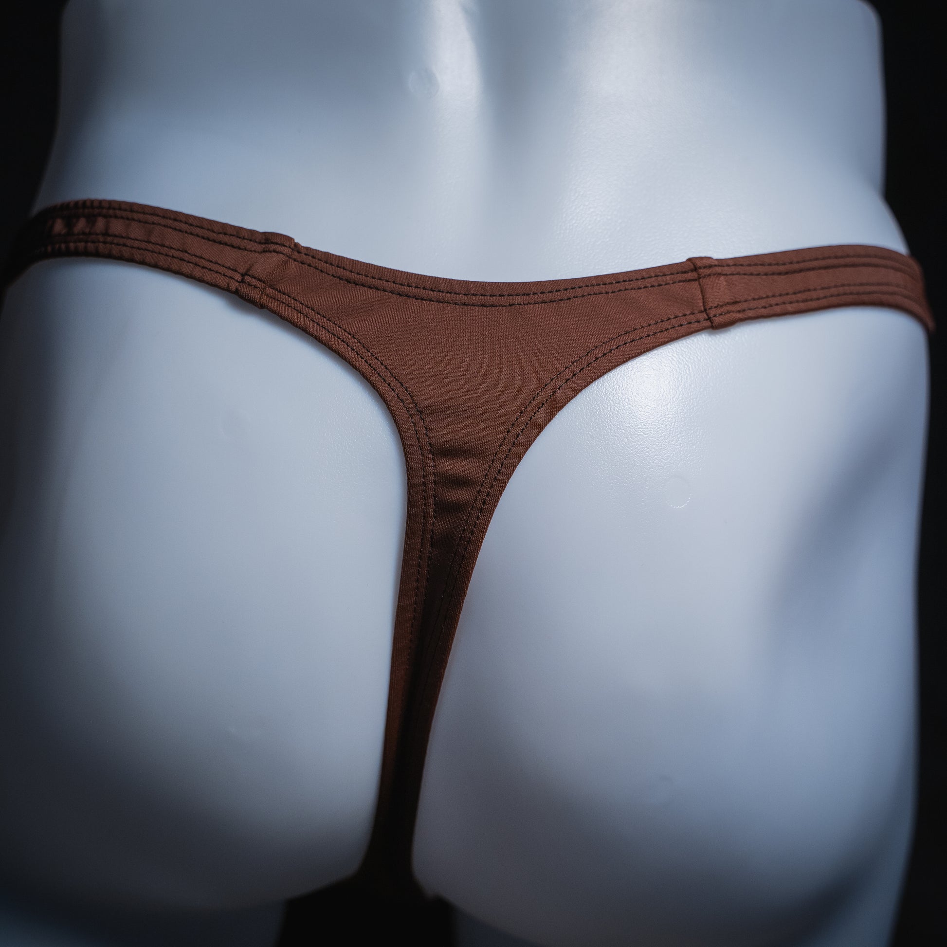 Men's solid brown thong, slim cut, rear view.