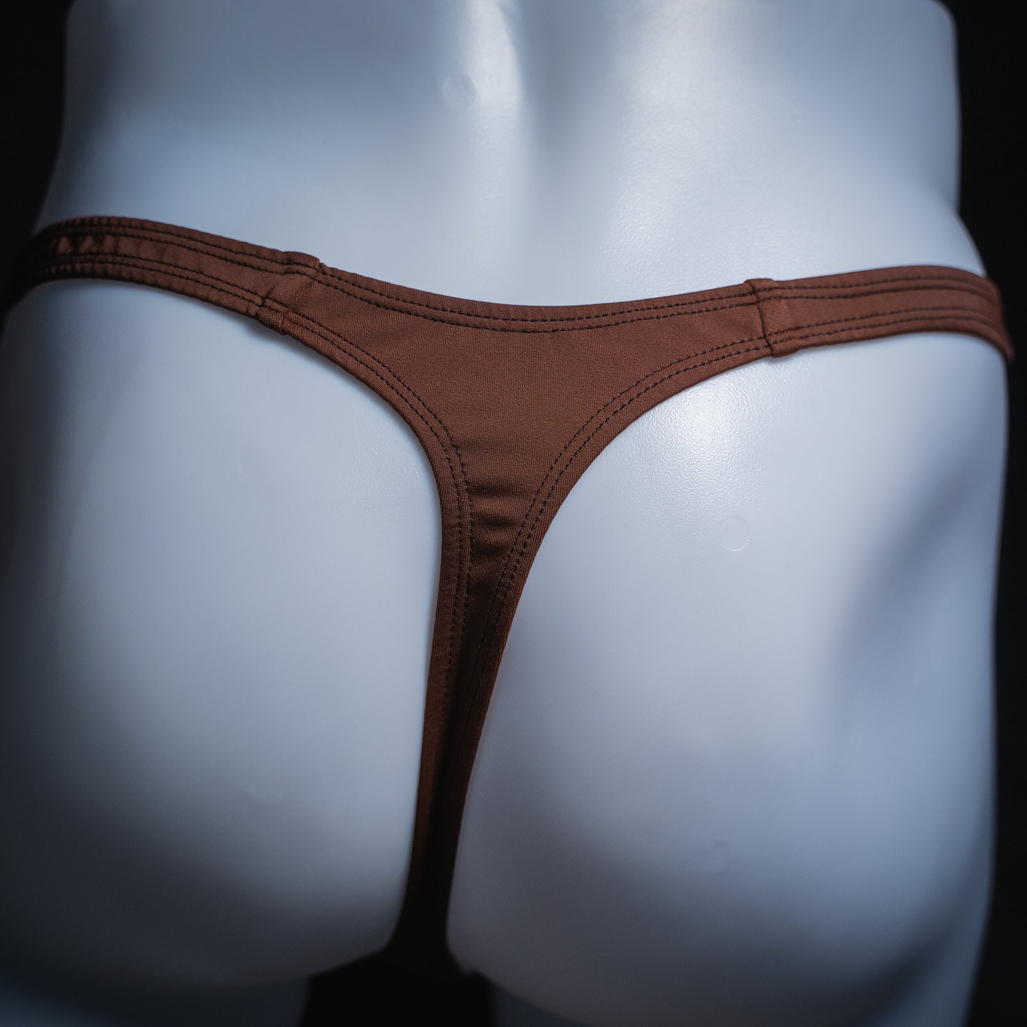 Men's solid brown thong, slim cut, rear view.
