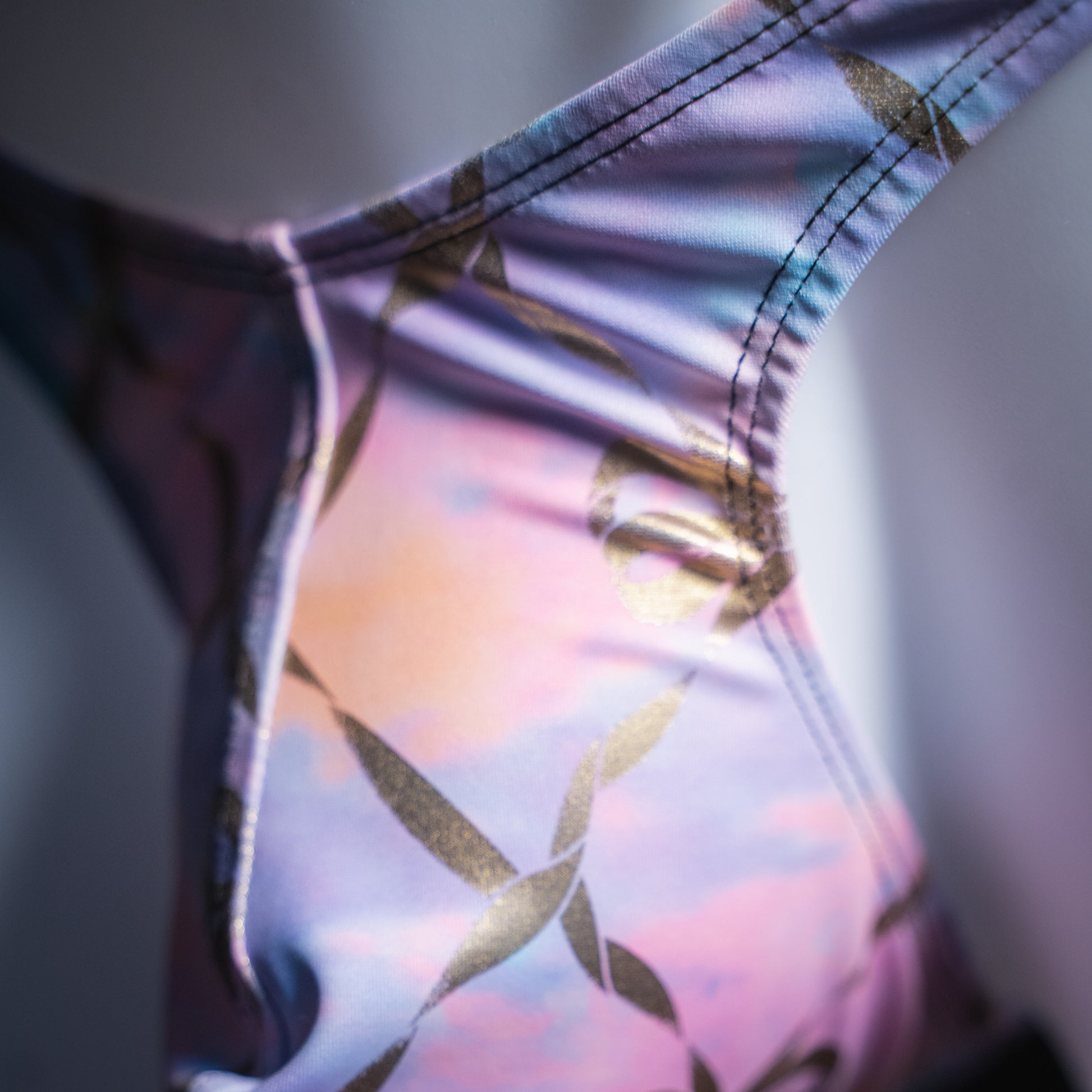 Men's pink and purple with gold foil chains thong, slim cut, closeup front view.