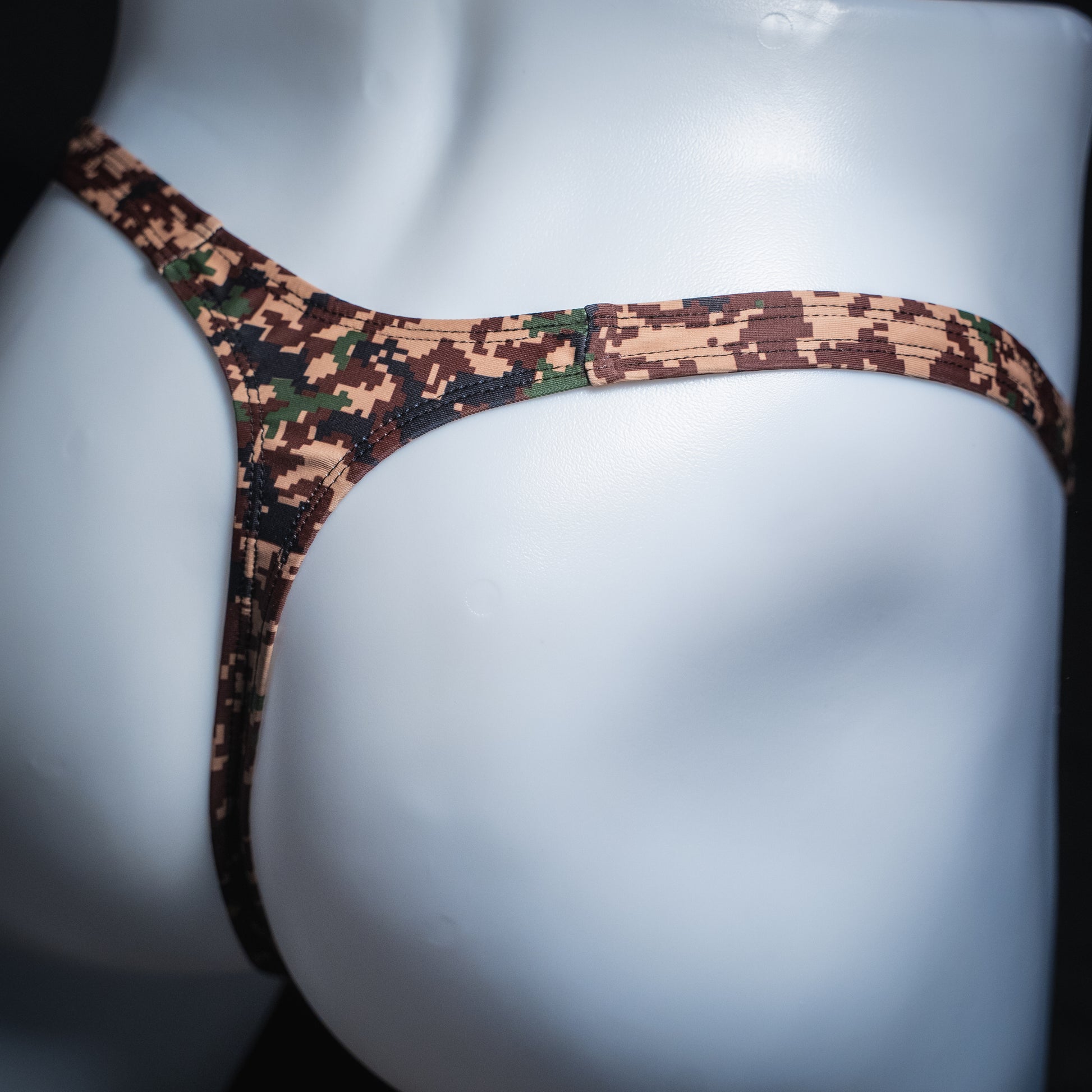 Men's digital camo thong, slim cut, angled rear view.