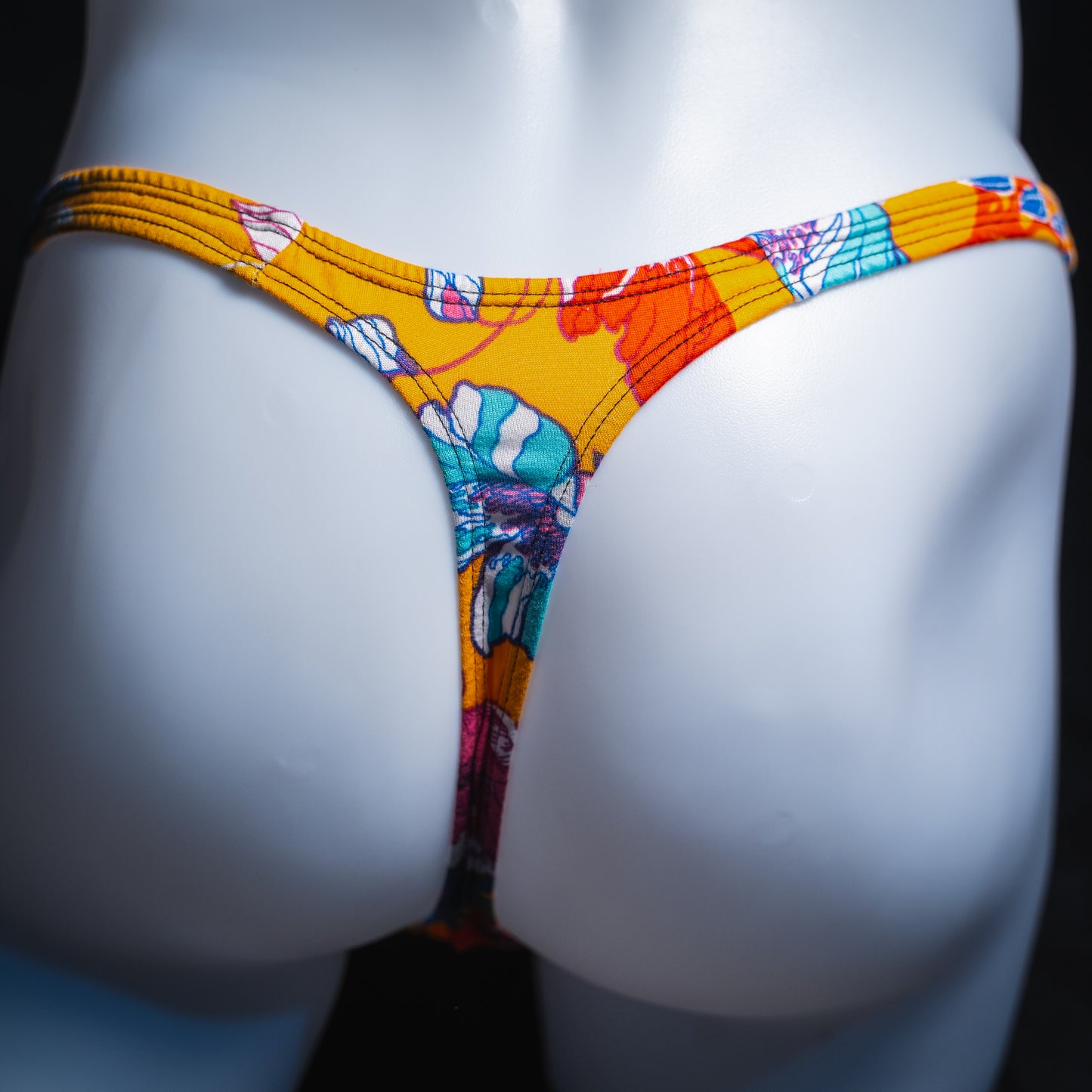Men's vintage orange floral thong, slim cut, rear view.
