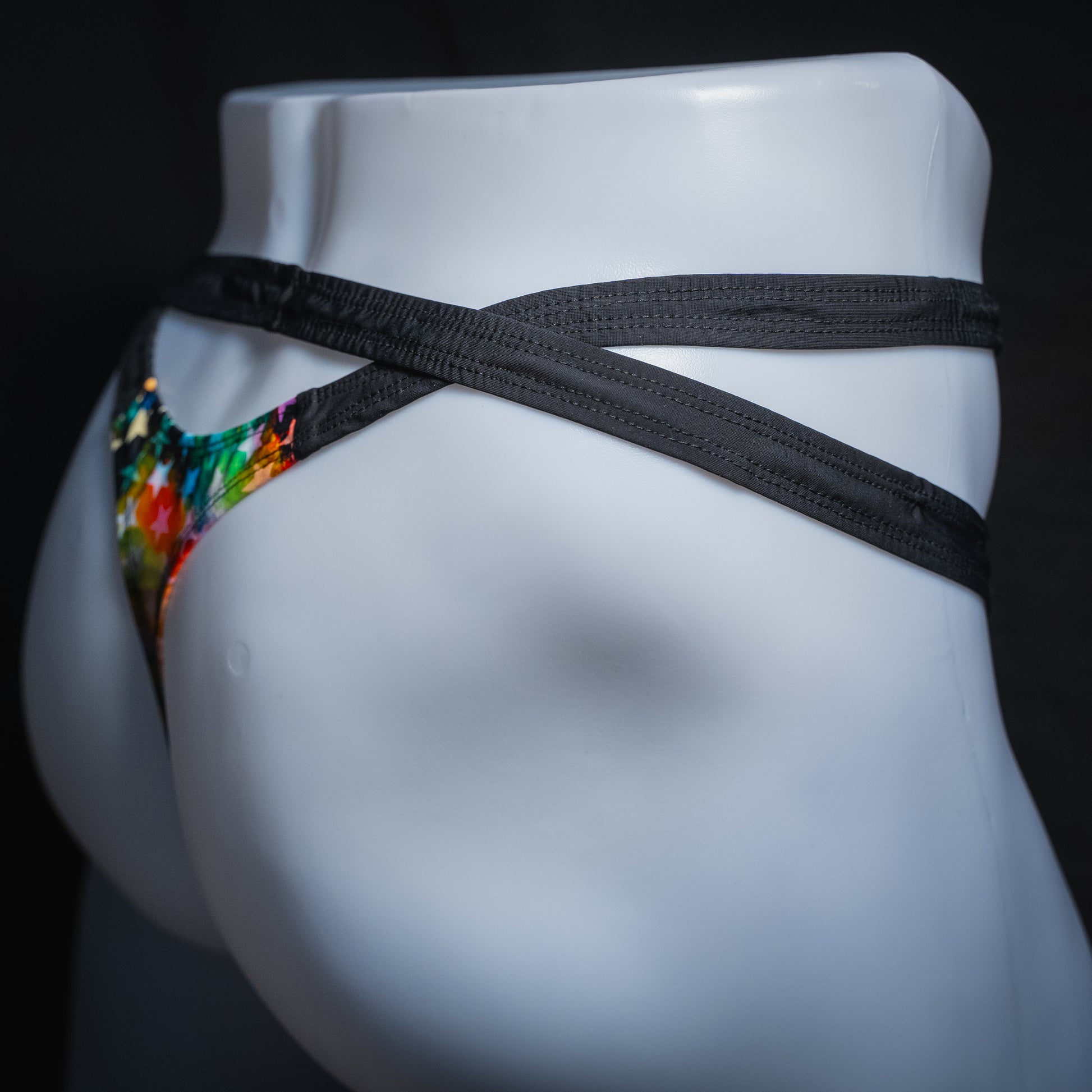 Men's double strap thong with star pattern, slim cut, side view.
