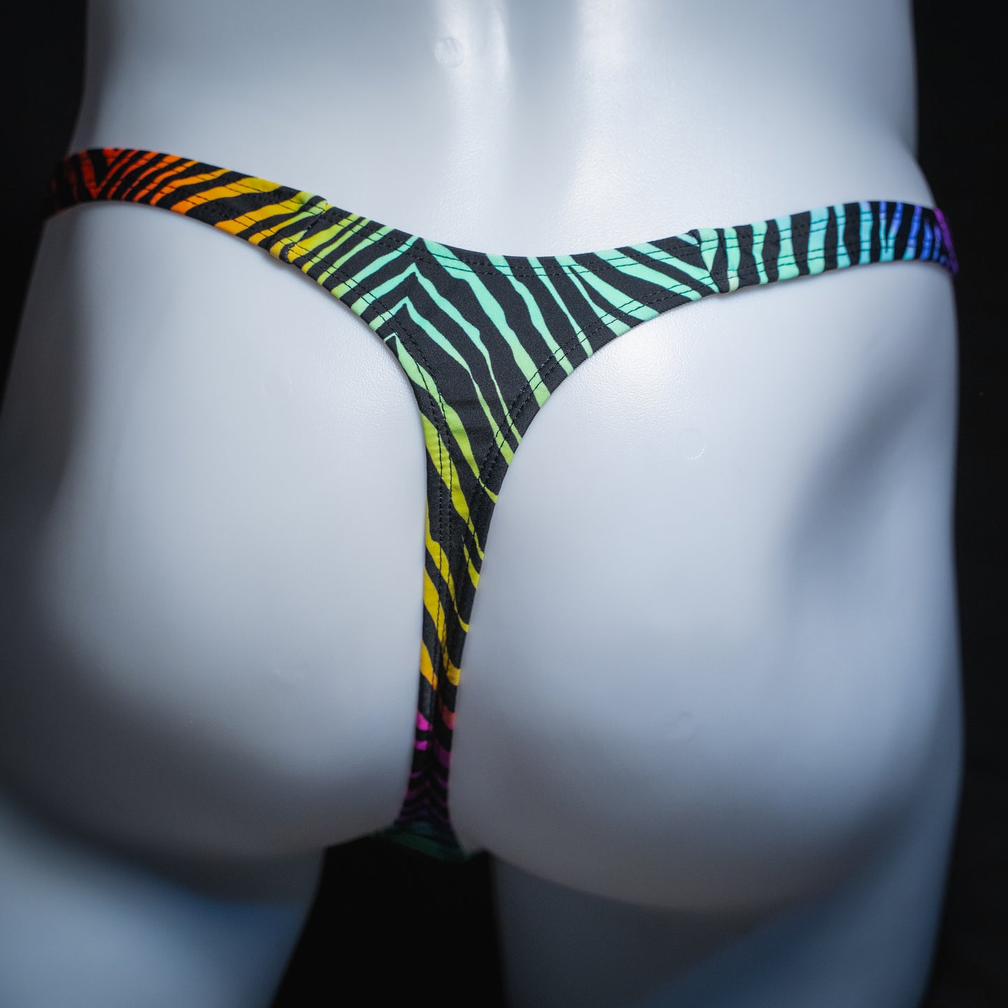 Men's rainbow zebra thong, slim cut, rear view.