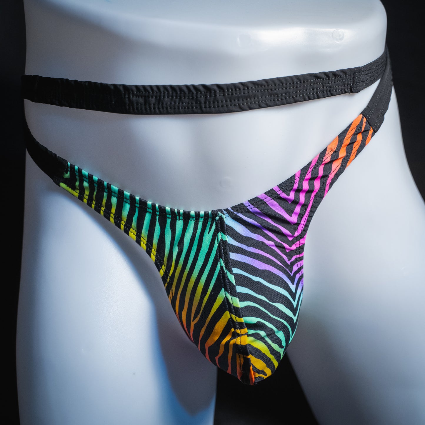 Men's rainbow zebra double strap thong, slim cut, front view.