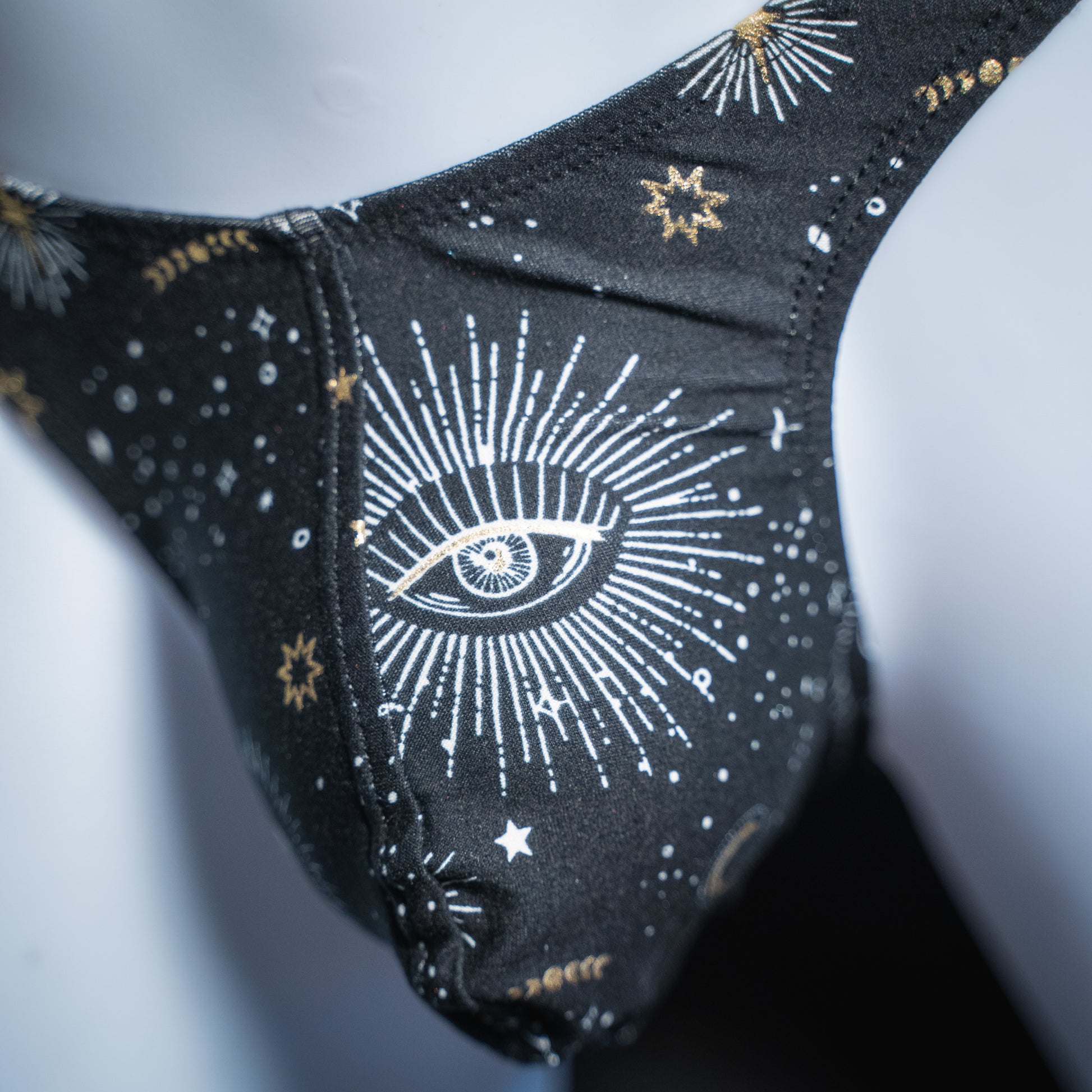 Men's black with supernatural eyes thong, slim cut, front closeup view.