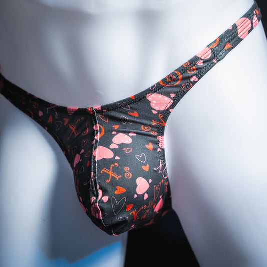 Men's black with read heart Valentines day thong, slim cut, angled front view.