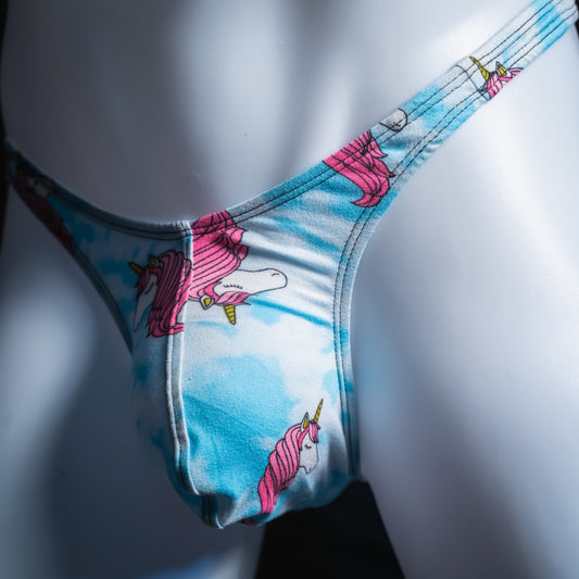 Men's blue clouds with pink unicorn heads thong, slim cut, angled front view.
