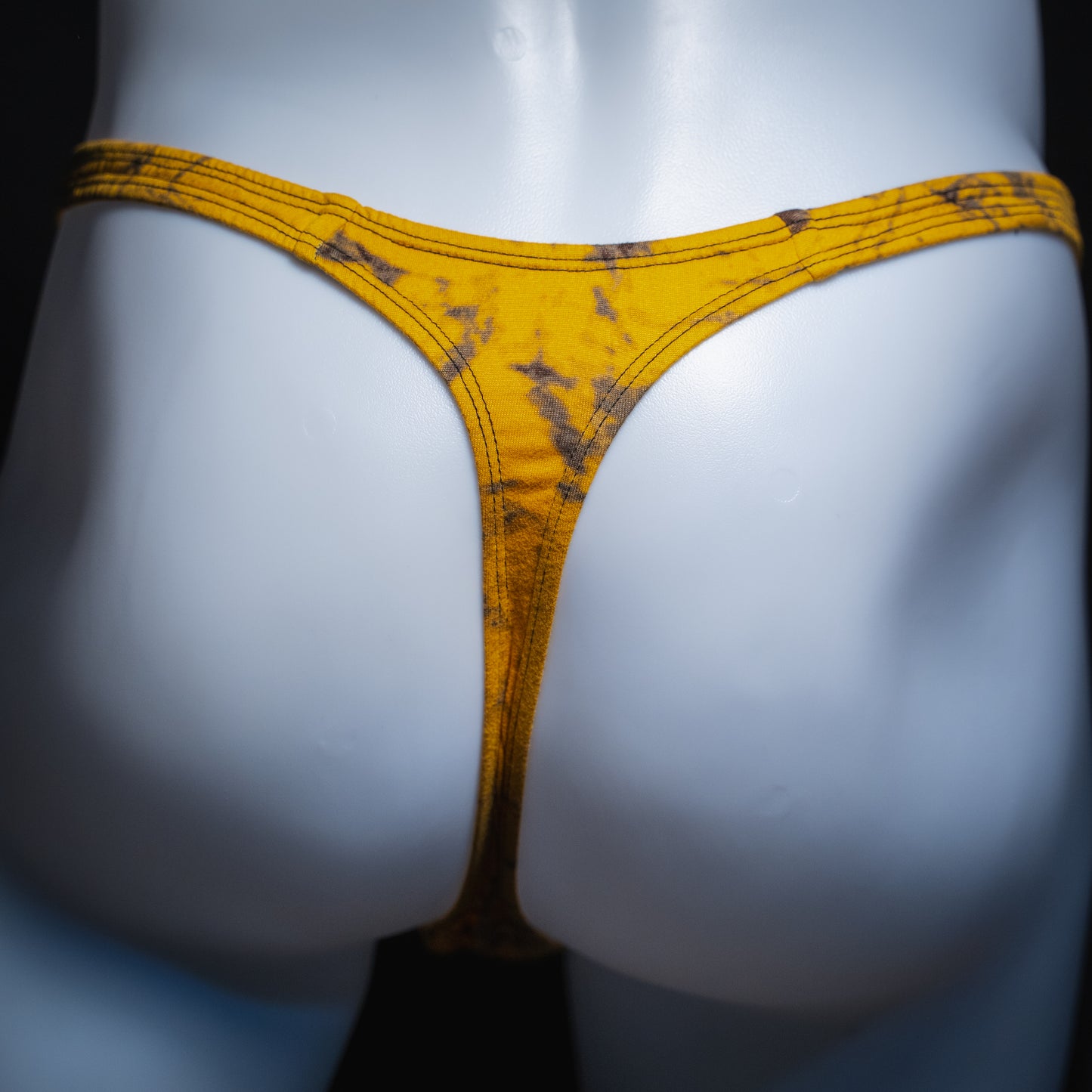 Men's yellow and black tie dye thong, classic cut, rear view.