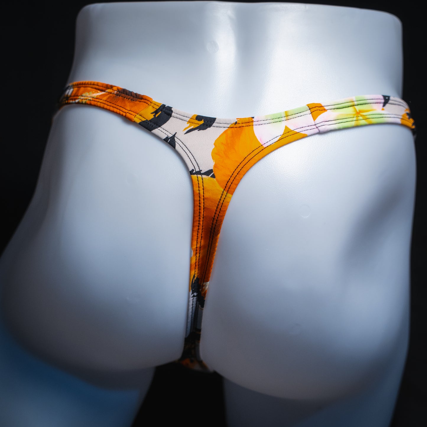 Men's orange floral thong, slim cut, back view.