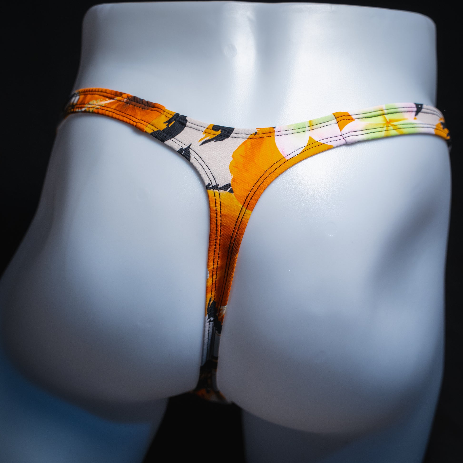 Men's orange floral thong, slim cut, back view.