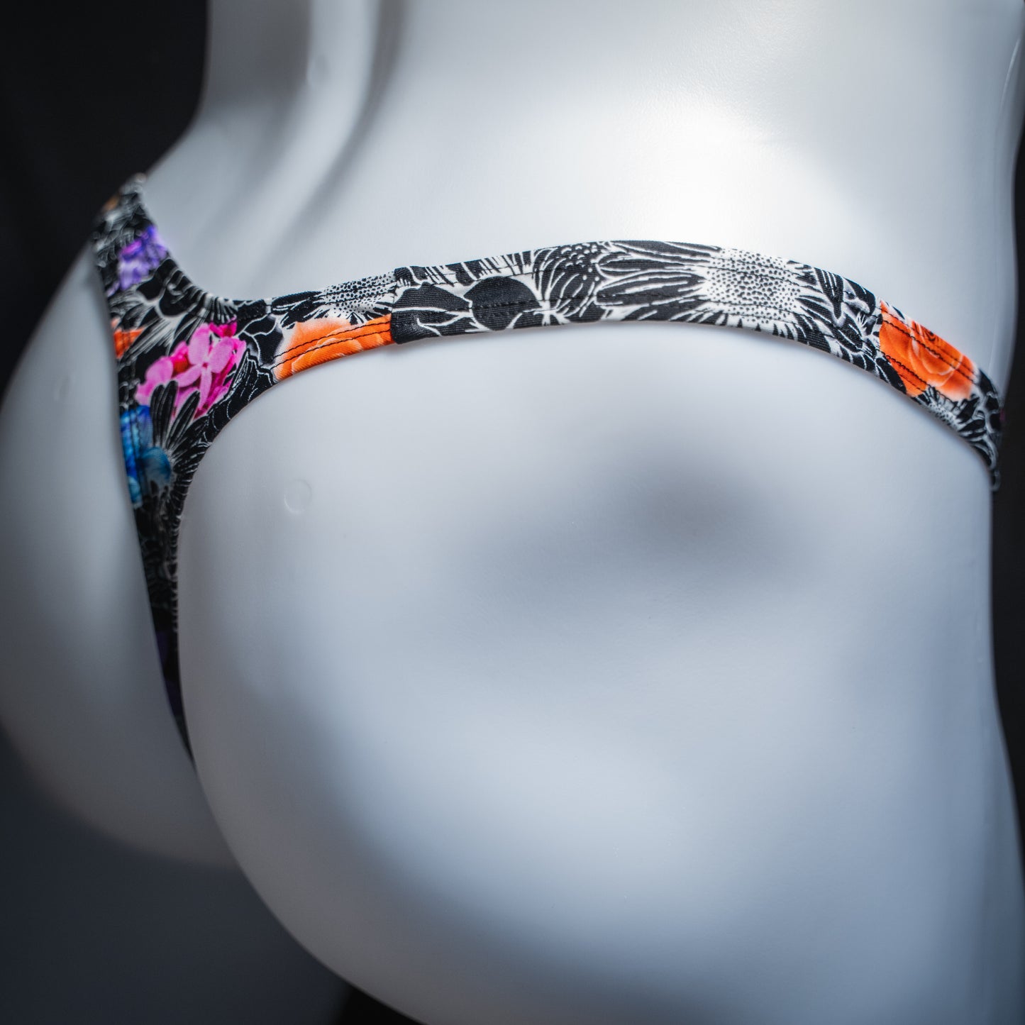 Men's sketch floral thong, slim cut, angled rear view.