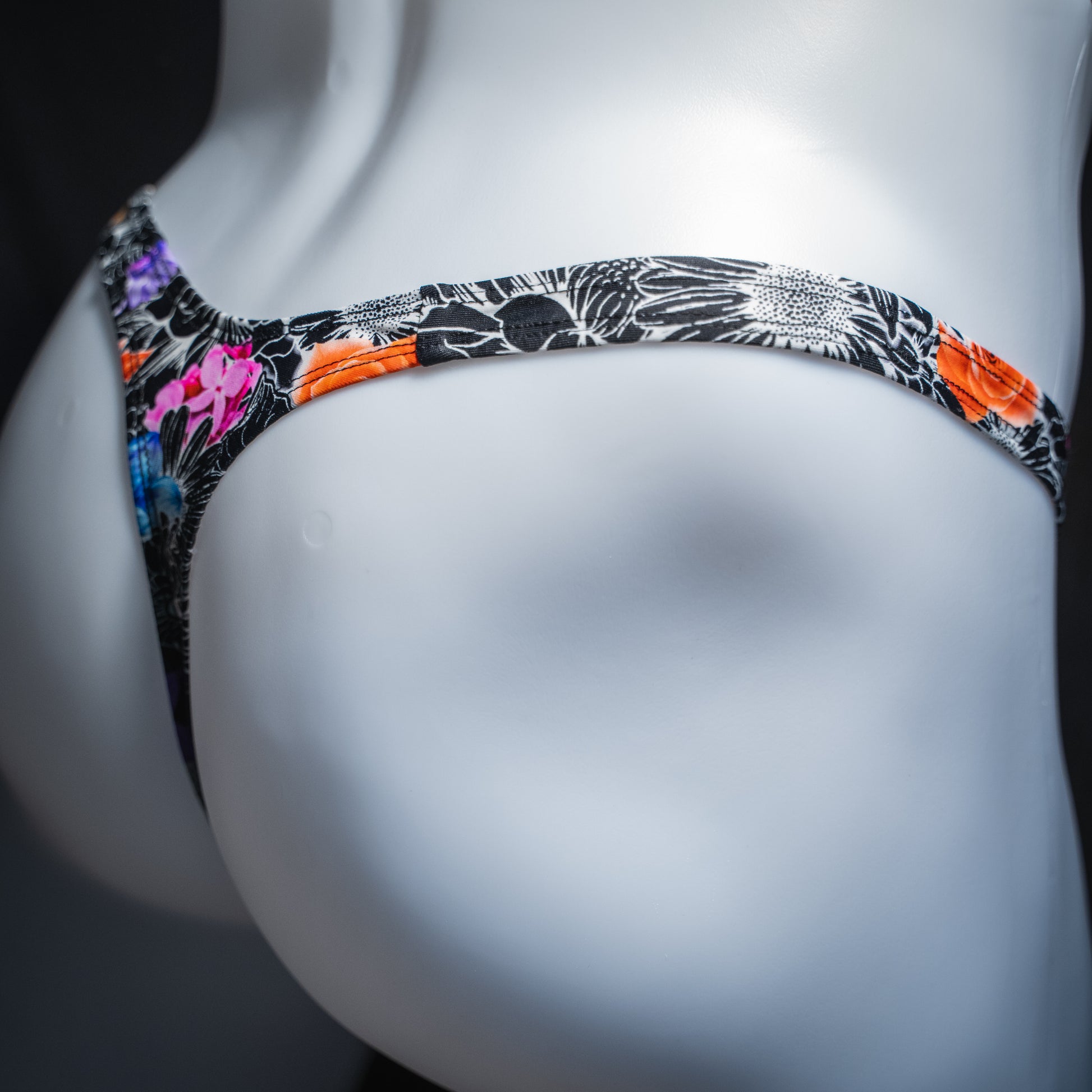 Men's sketch floral thong, slim cut, angled rear view.