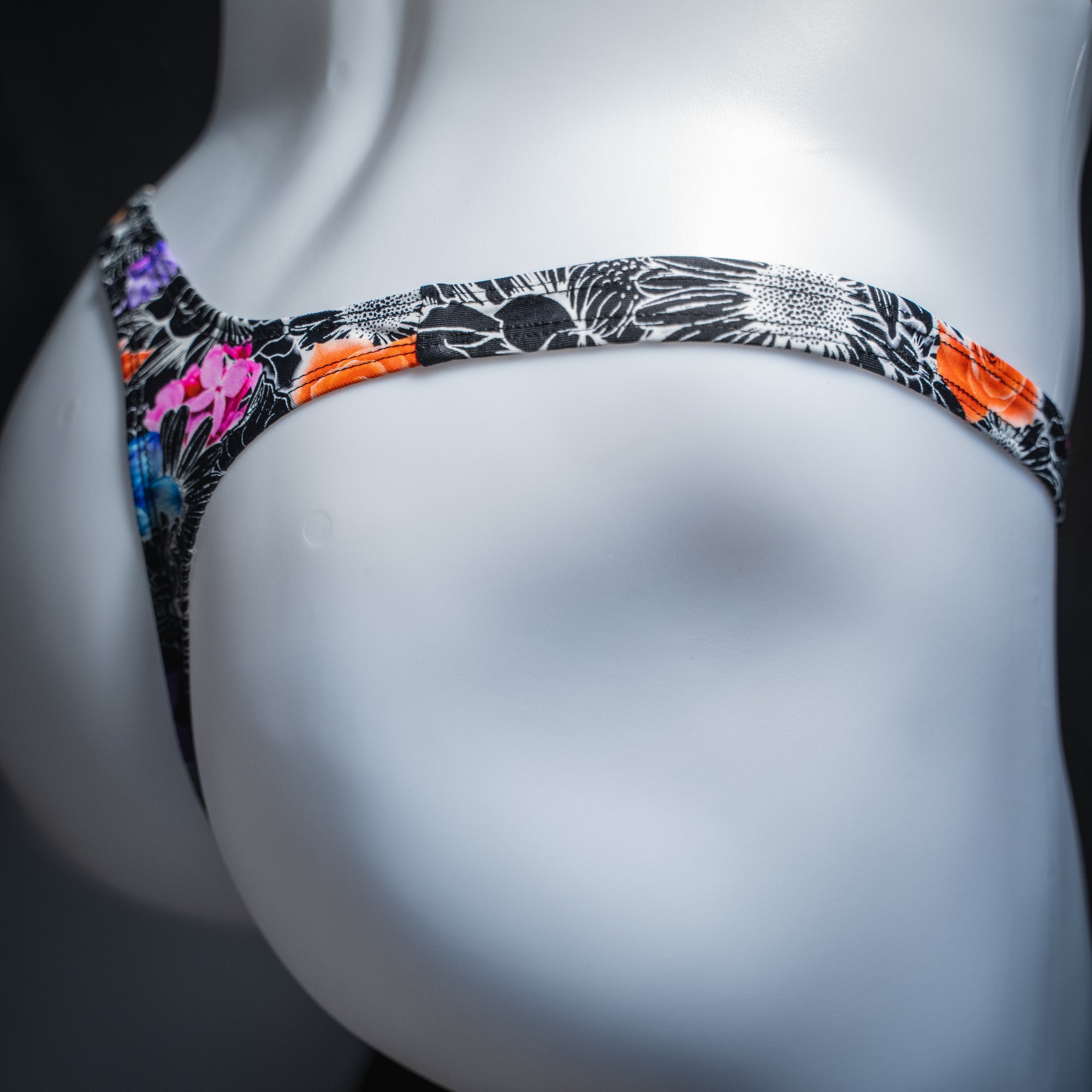 Men's sketch floral thong, slim cut, angled rear view.