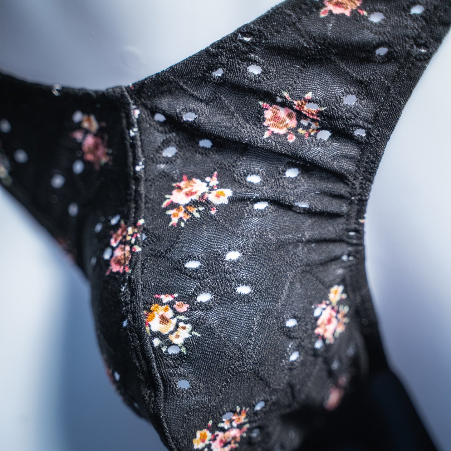 handmade mens thong underwear, black floral eyelet pattern, soft polyester material, classic cut variation, closeup angled front view