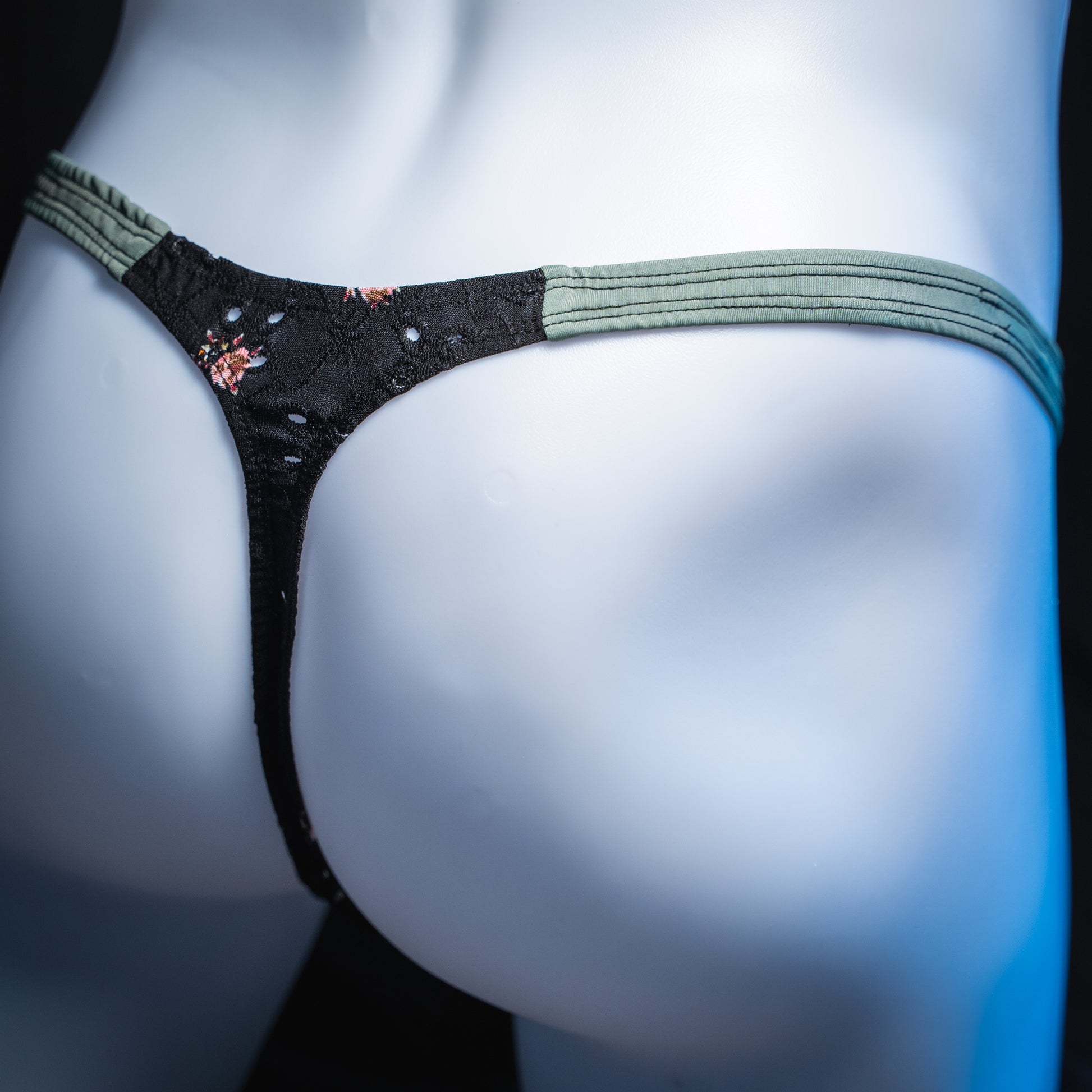 handmade mens thong underwear, black floral eyelet pattern, soft polyester material, classic cut variation, angled back view