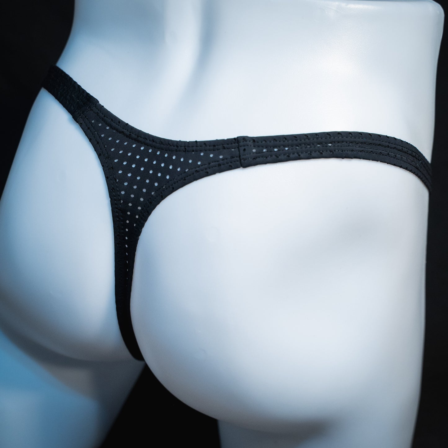 men's black mesh thong underwear, slim cut, angled rear view.