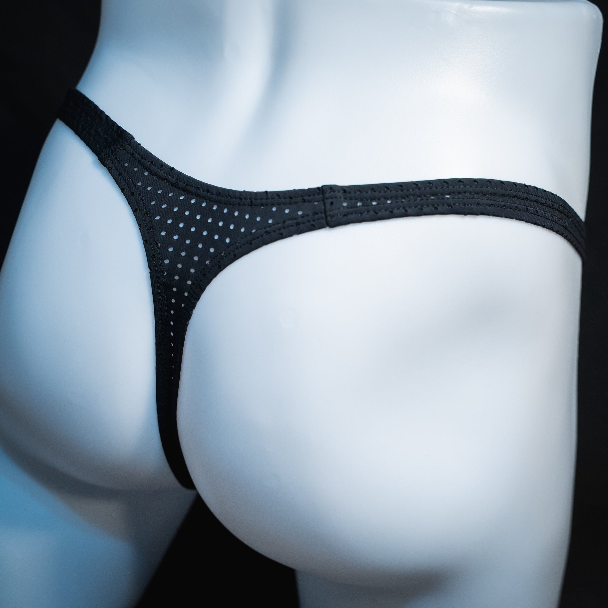 men's black mesh thong underwear, slim cut, angled rear view.
