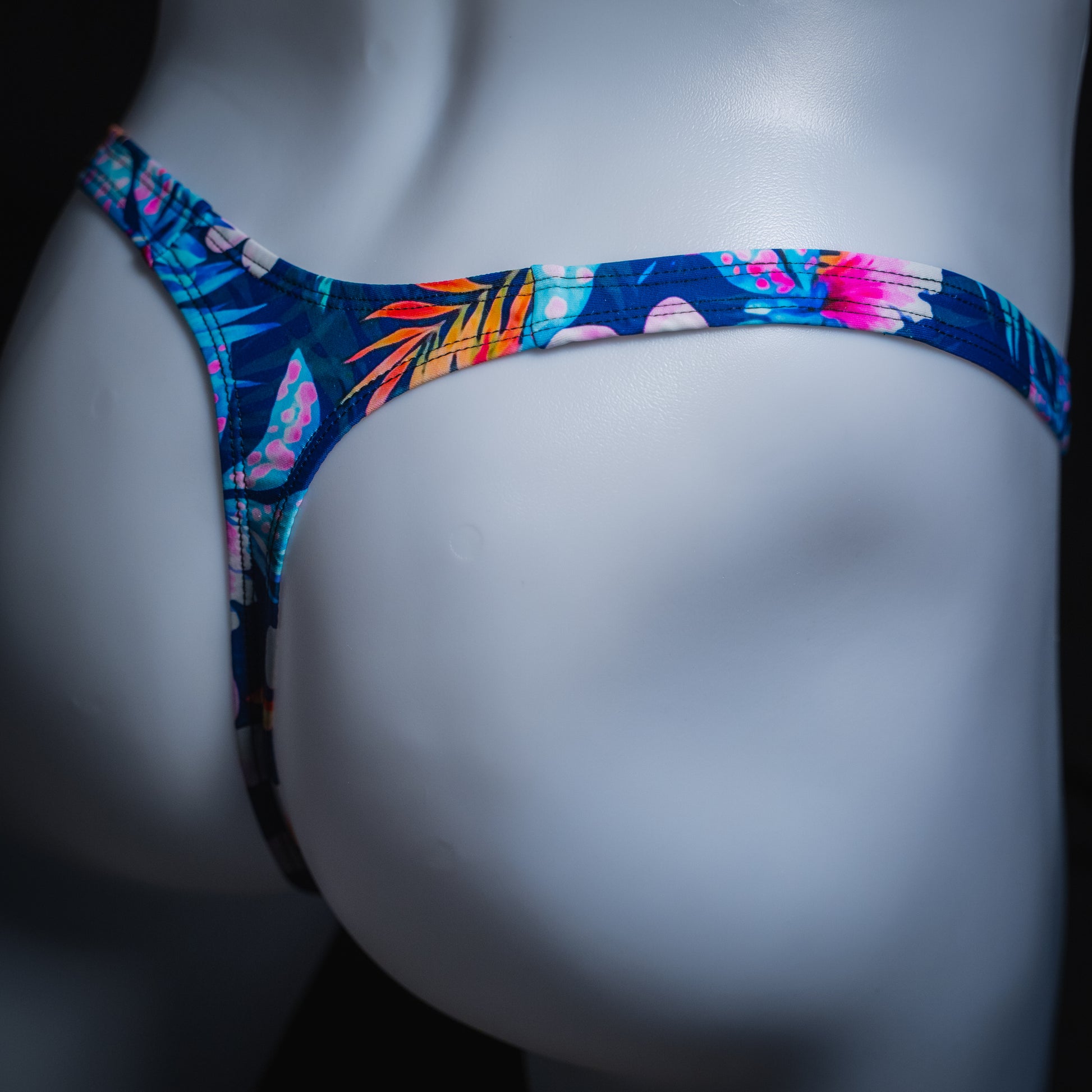 Mens' blue floral thong, slim cut, angled rear view.