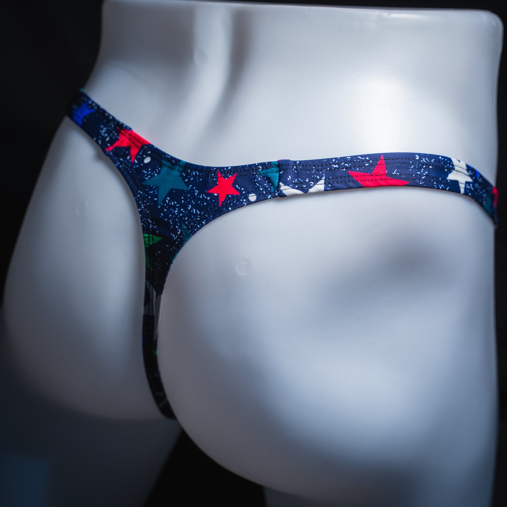 Men's stars on blue thong, slim cut, angled rear view.