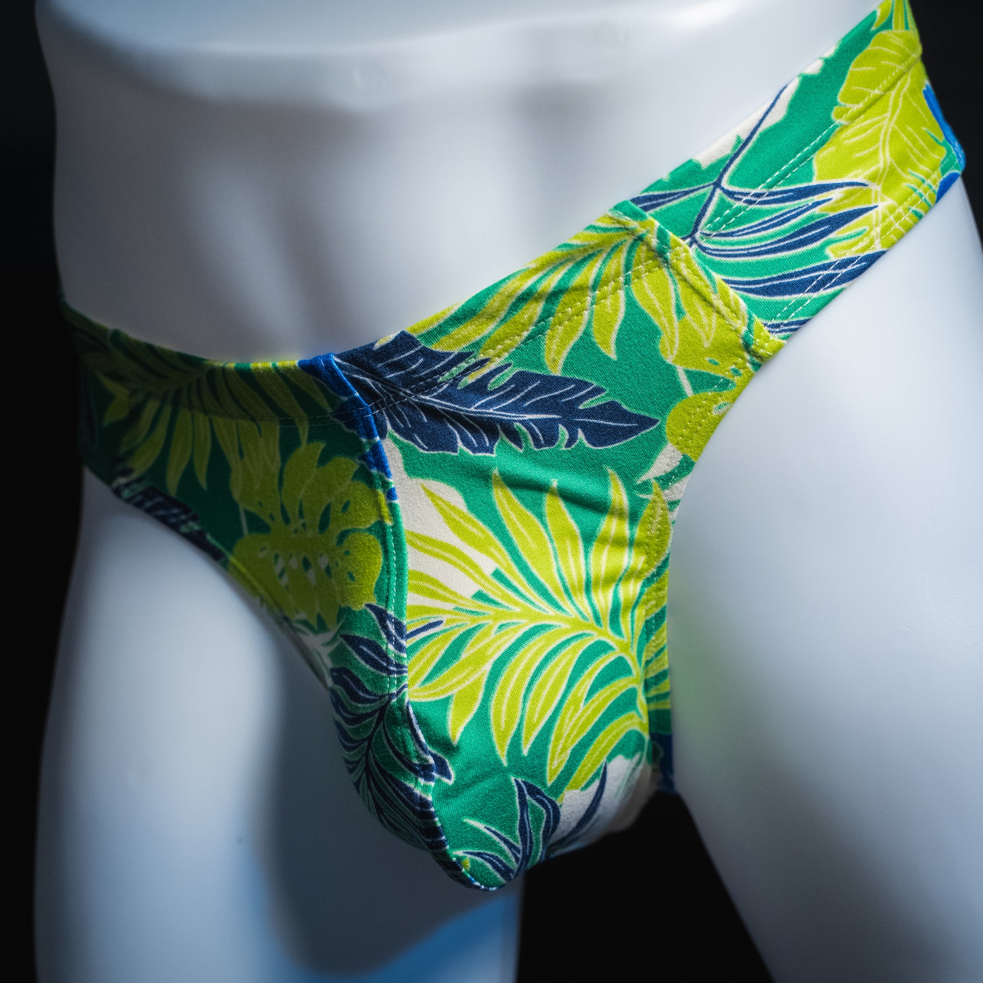 handmade mens thong underwear, green tropical leaves print, soft polyester material, brief cut design, angled front view