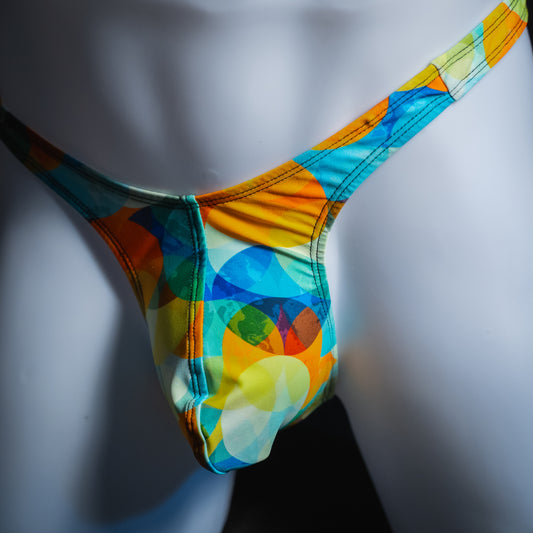 Men's colorful orb thong, slim cut, angled front view.