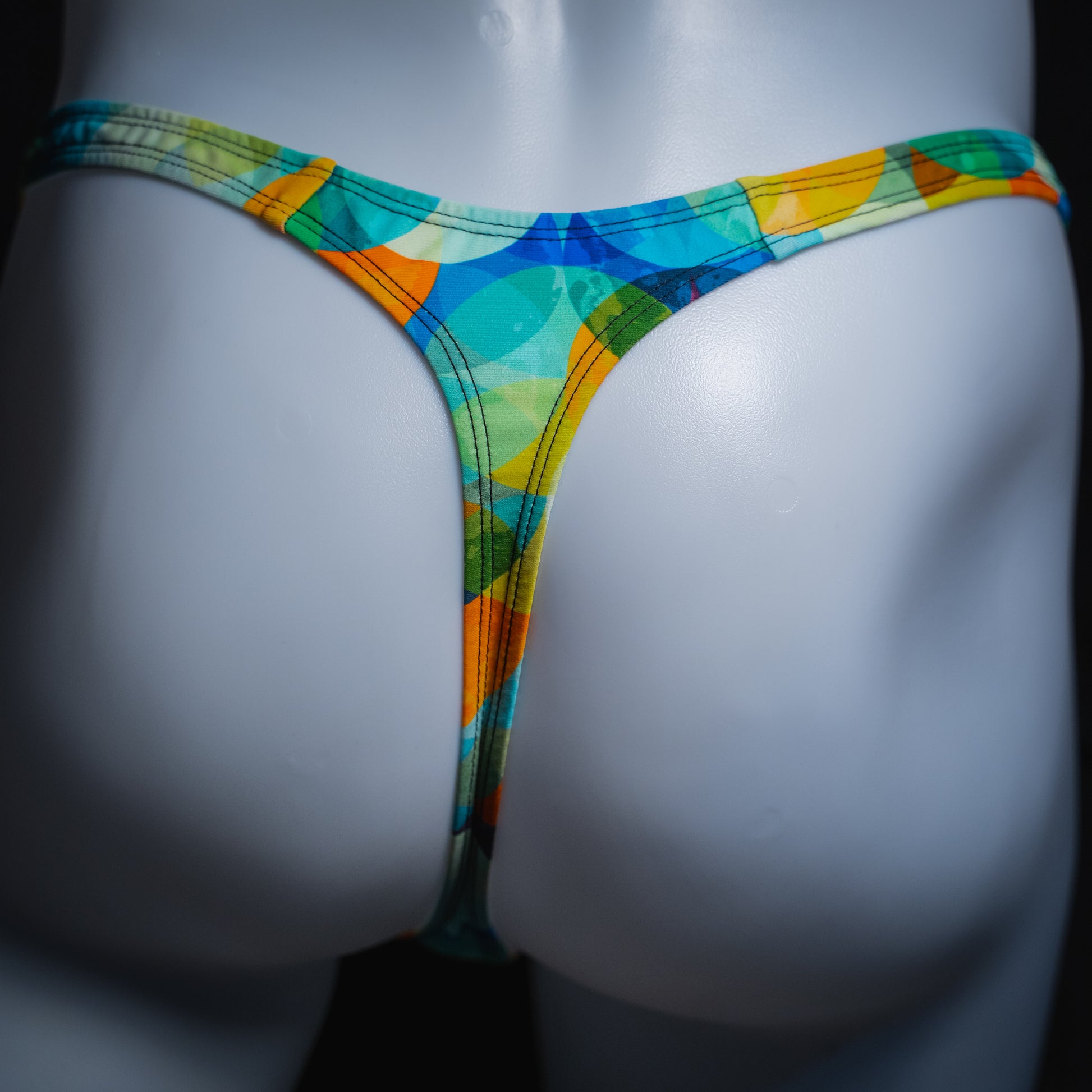 Men's colorful orb thong, slim cut, rear view.