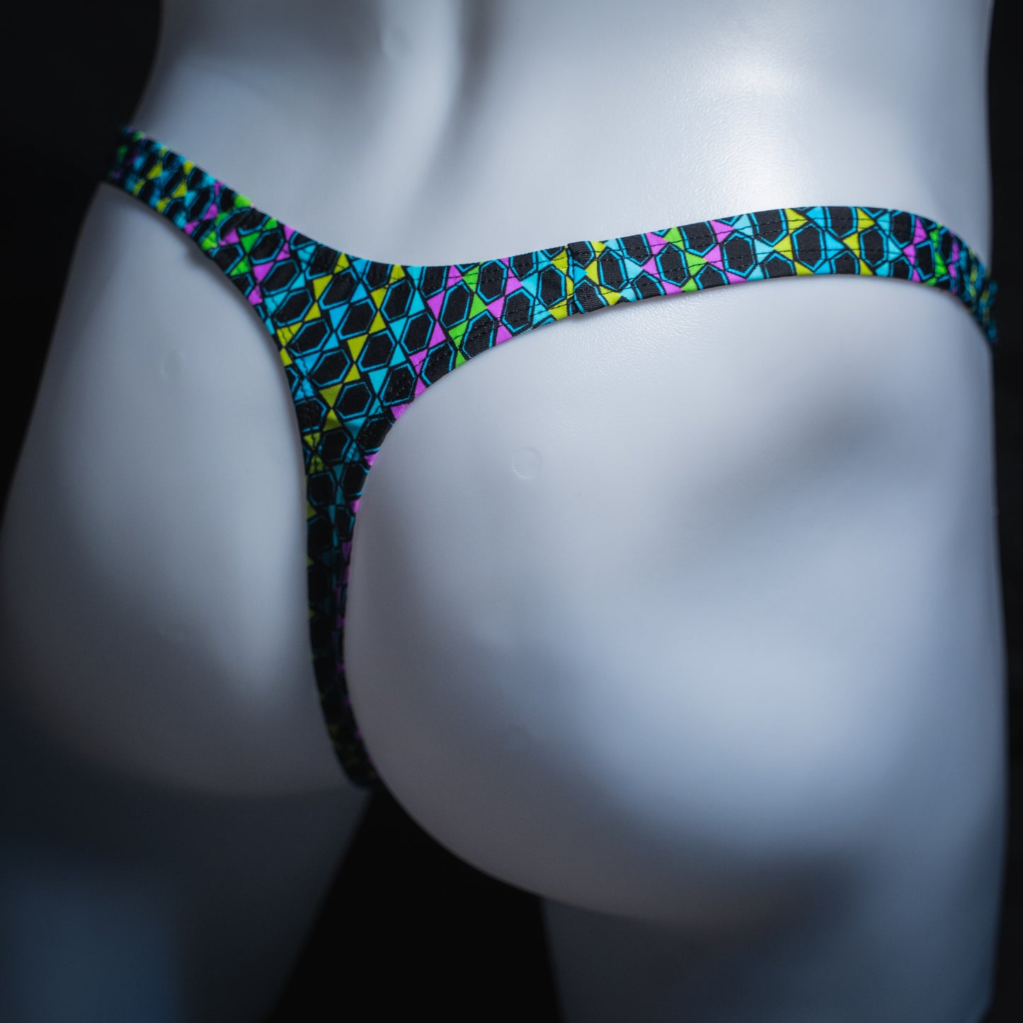 Men's colorful wavy line thong, slim cut, angled rear view.