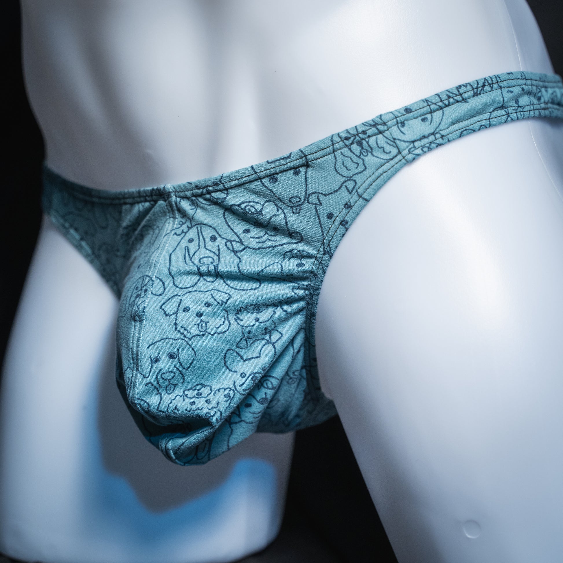 Men's dog faces on blue thong, classic cut, angled front view.