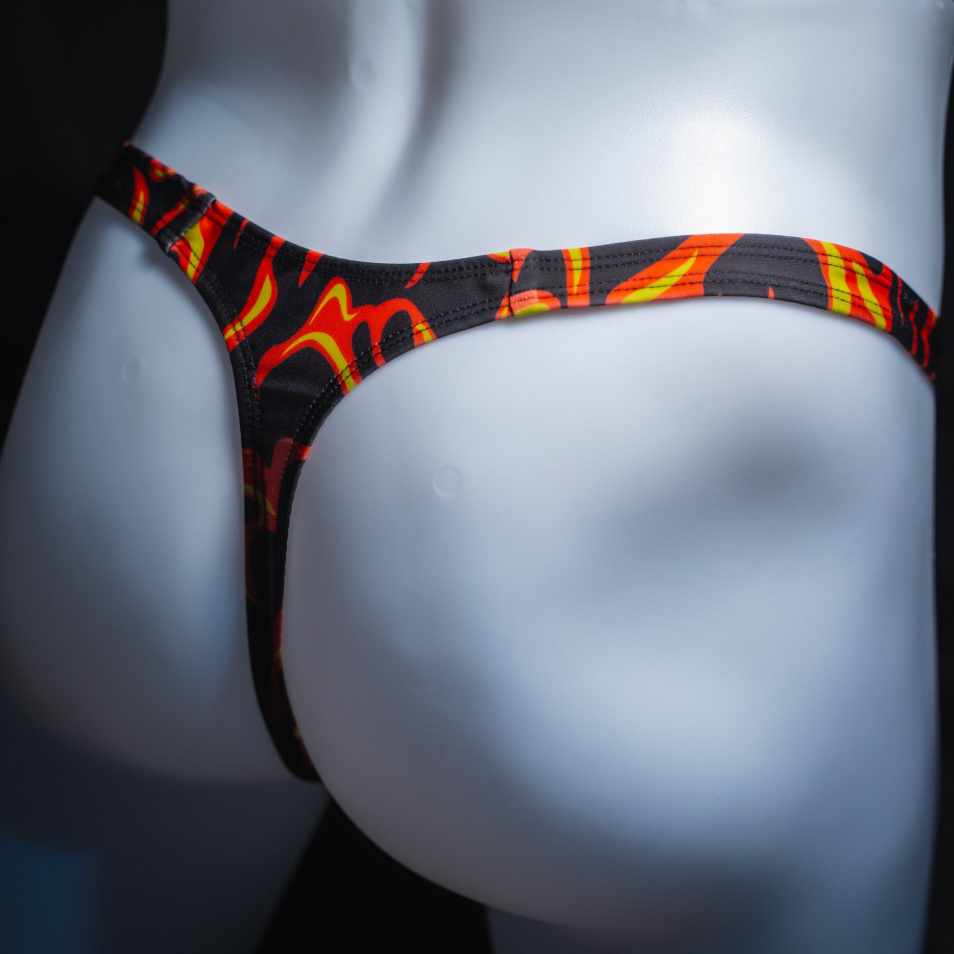 Men's flame thong, slim cut, angled rear view.