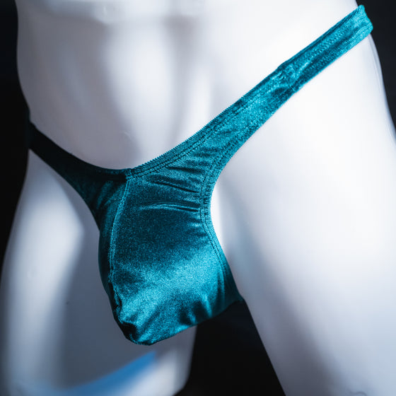 Men's green velvet thong, slim cut, angled front view.