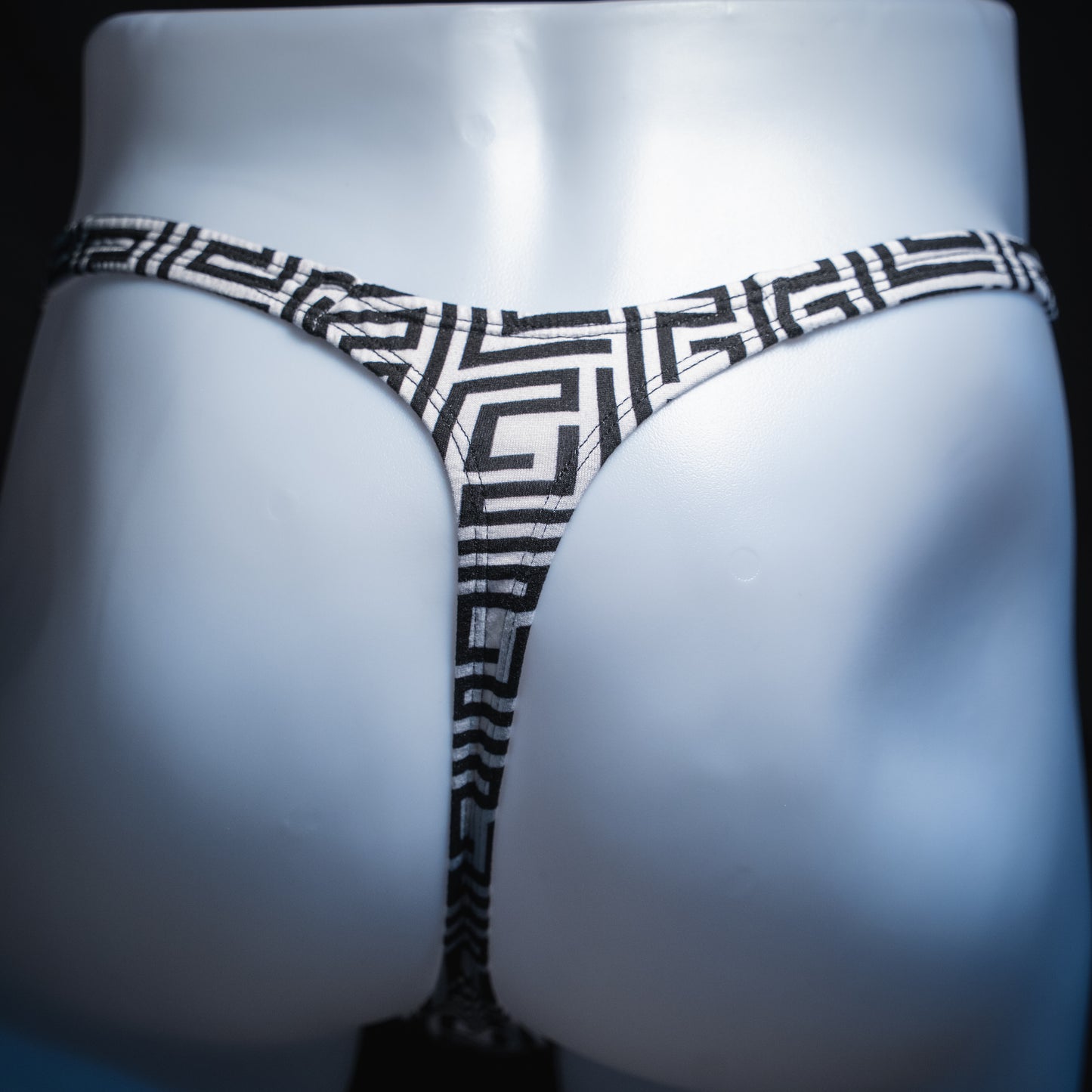 Men’s black-and-white geometric thong underwear, classic cut, back view.