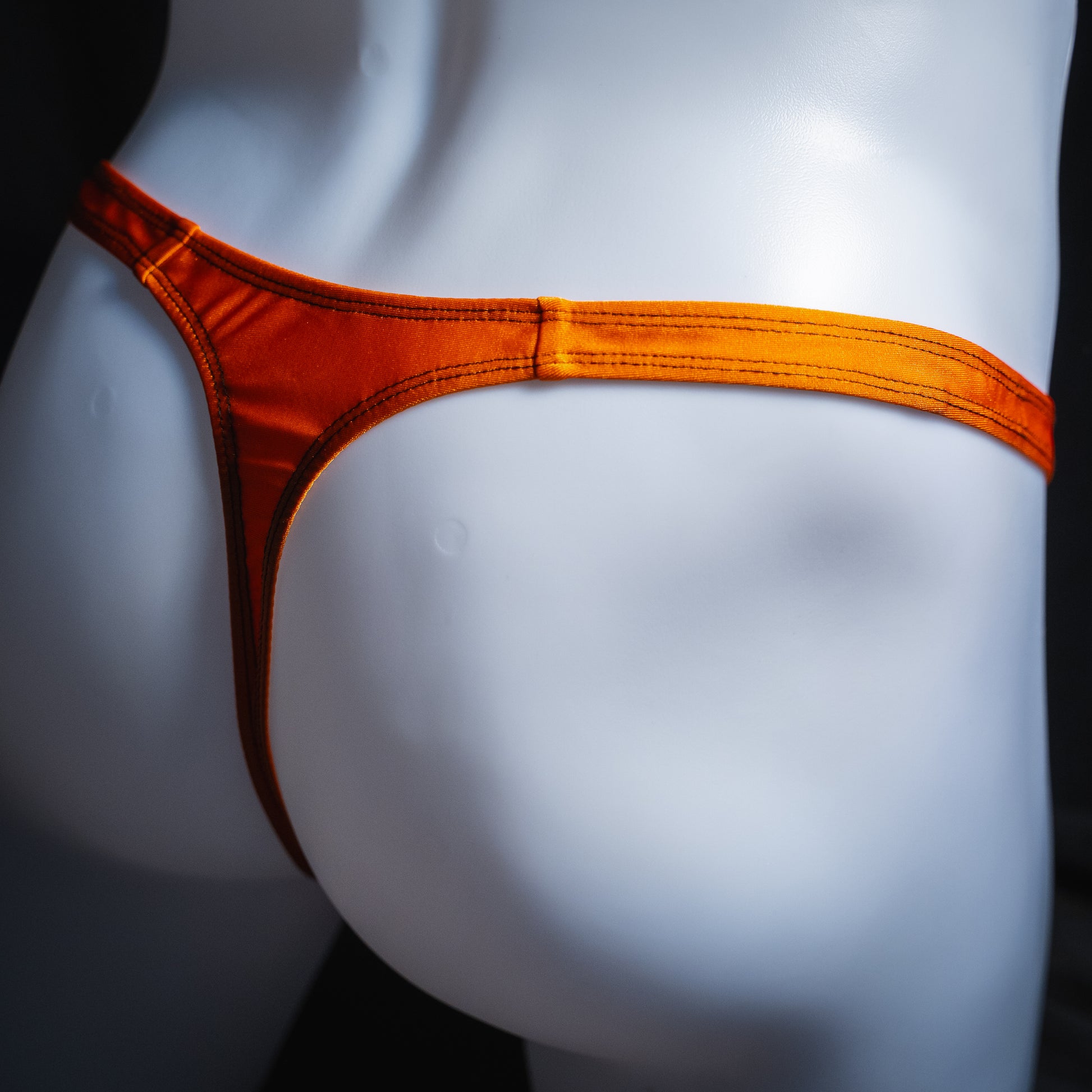 handmade mens thong underwear, solid orange print, spandex material, classic cut variation, angled back view