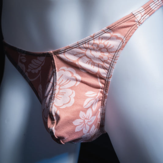 Men's mauve with white flowers thong, classic cut, angled front view.