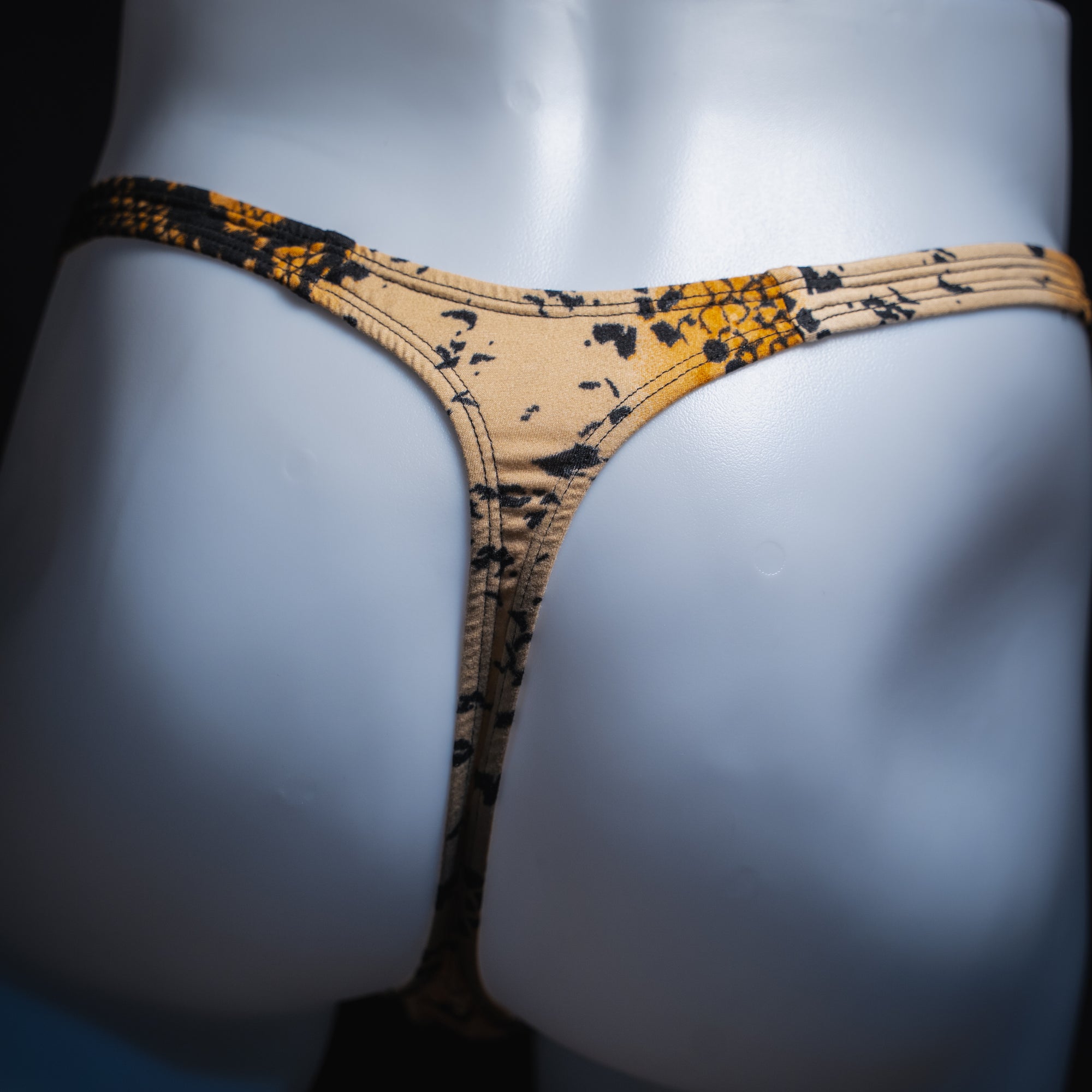 Men's mud snakeskin thong, classic cut, back view.