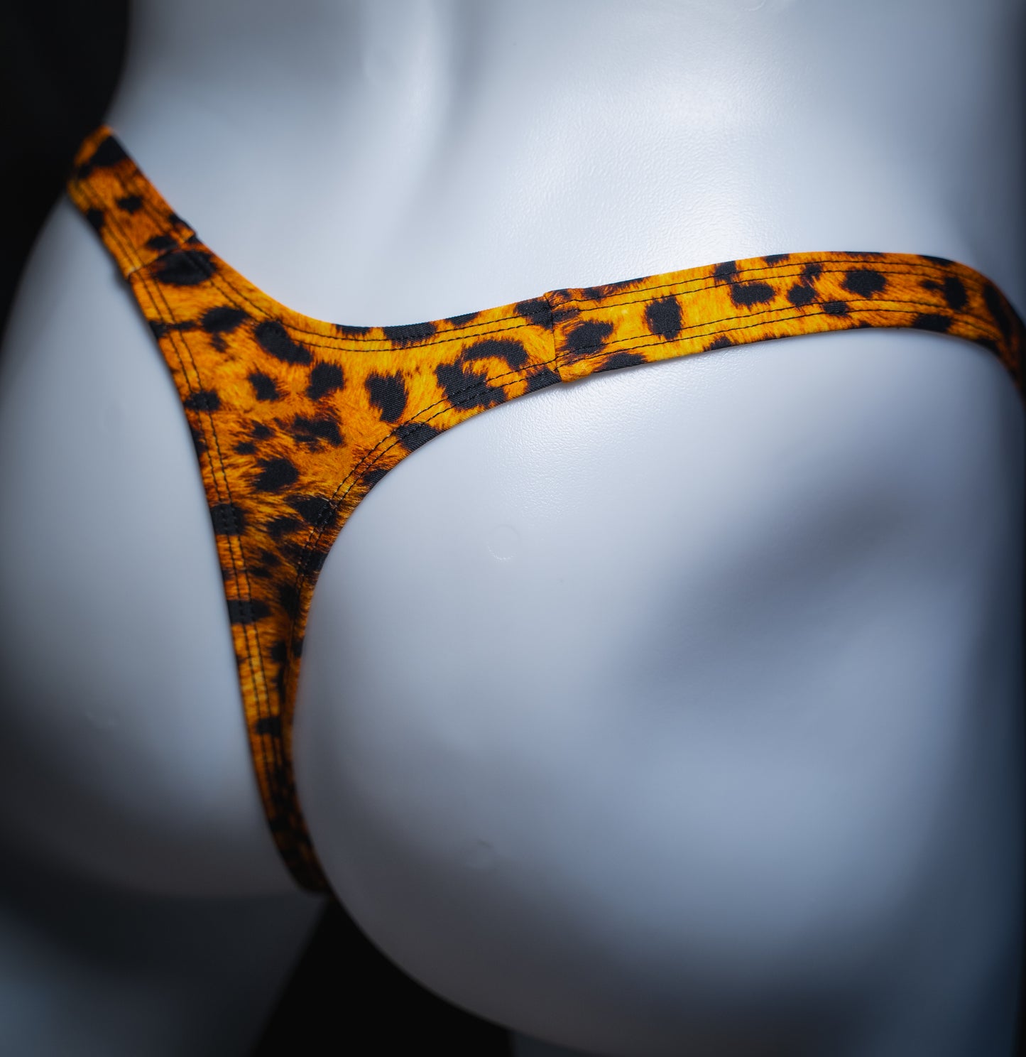 handmade mens thong underwear, orange cheetah print, spandex material, slim cut, angled back view
