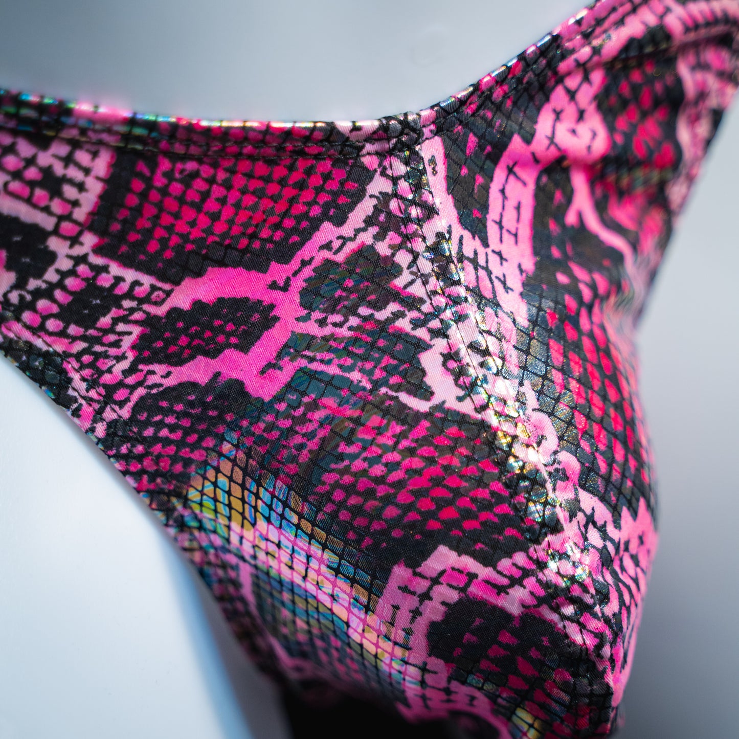 Men's pink metallic snakeskin-print thong underwear, classic cut, front closeup.