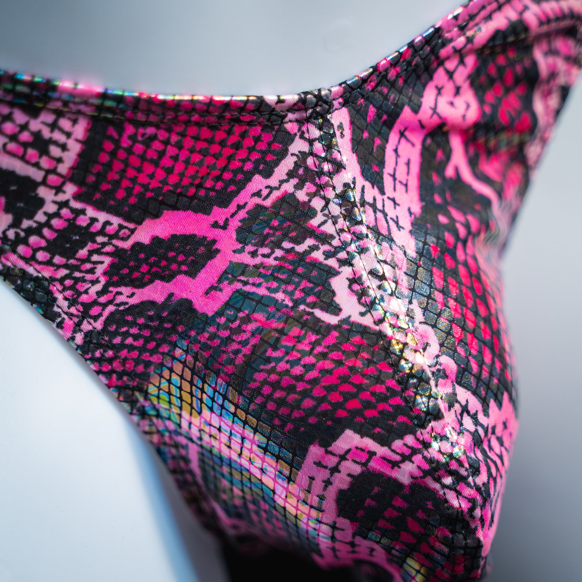 Men's pink metallic snakeskin-print thong underwear, classic cut, front closeup.