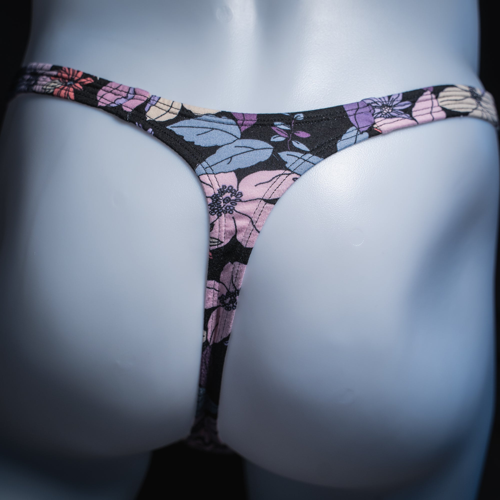 Men's purple floral thong, slim cut, rear view.