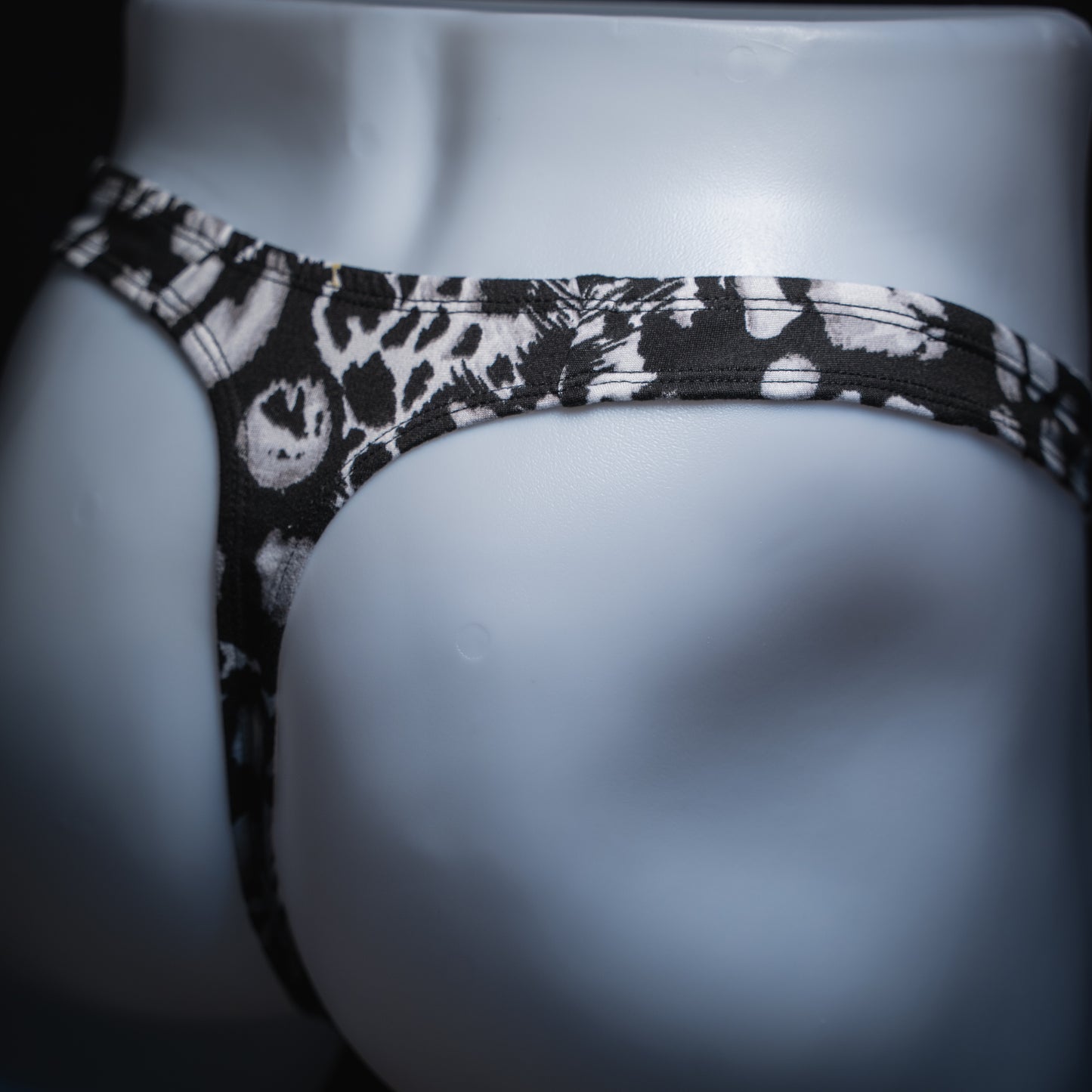 handmade mens thong underwear, white animal print, soft polyester material, robust cut design, angled back view