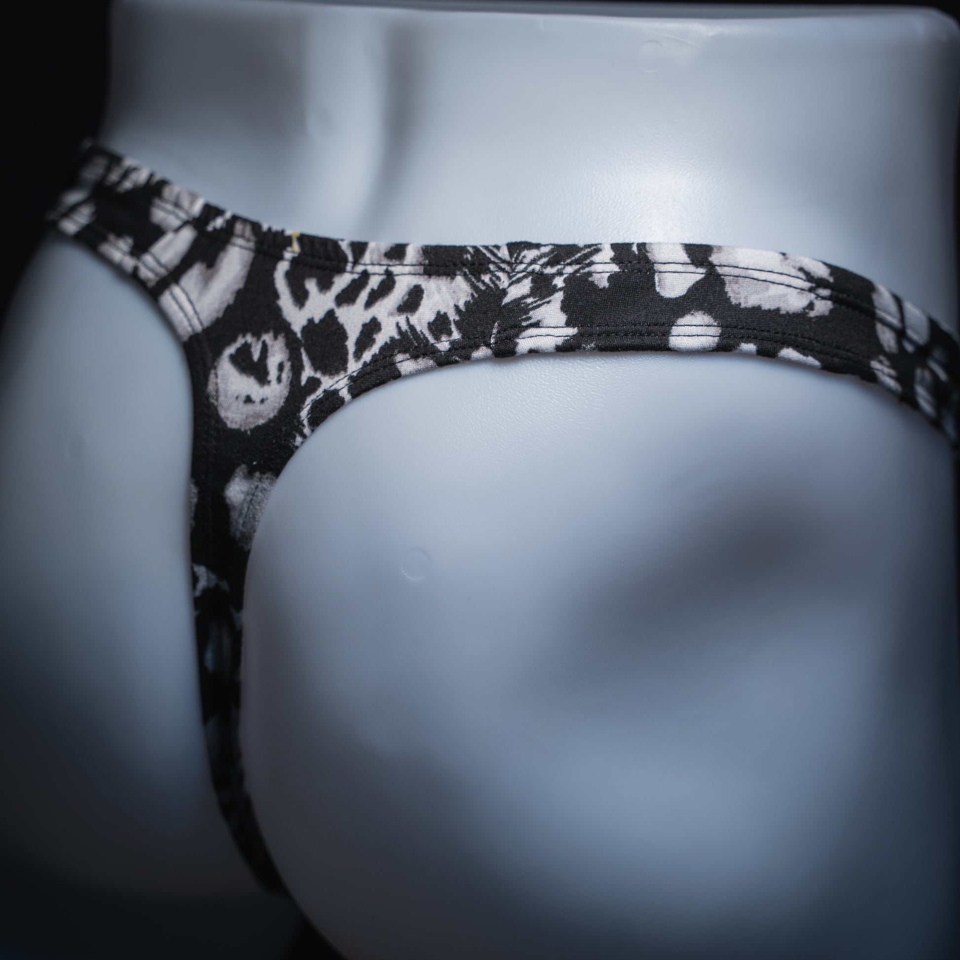 handmade mens thong underwear, white animal print, soft polyester material, robust cut design, angled back view