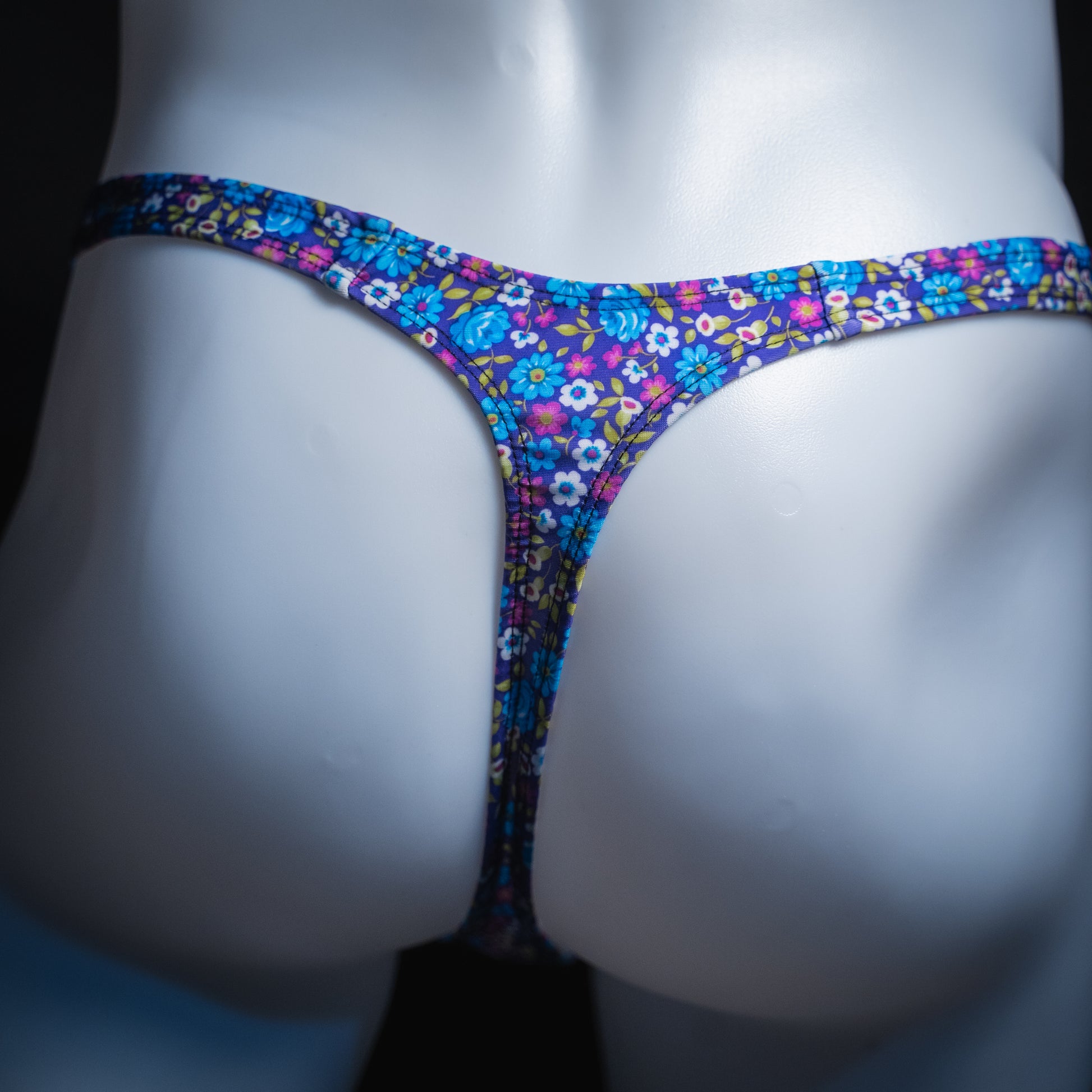 Men's purple and blue floral thong, sim cut, rear view.